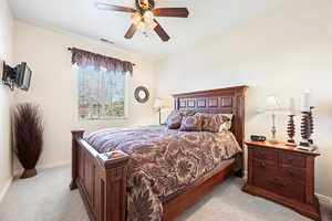 Bedroom with ceiling fan and light carpet