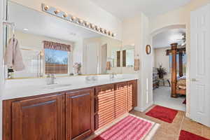 Bathroom with tile patterned flooring, vanity, ceiling fan, and walk in shower