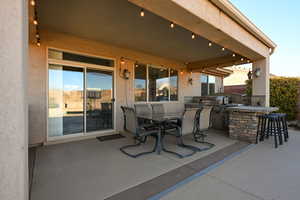 View of patio / terrace with an outdoor kitchen, area for grilling, and a bar