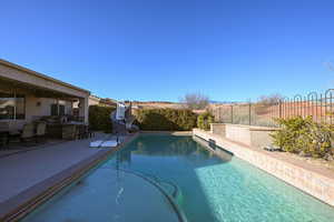 View of swimming pool with a water slide, exterior kitchen, and a patio