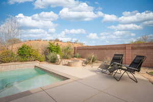 View of pool with a fenced in pool, a patio, a fire pit, and fence