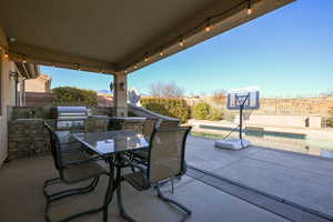 View of patio featuring area for grilling and a fenced in pool