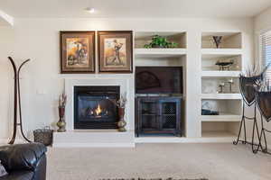 Living room featuring built in features, a textured ceiling, and carpet