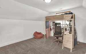 Office area with lofted ceiling and carpet