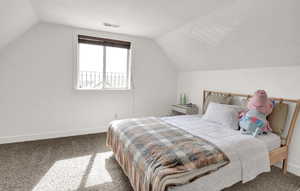 Bedroom featuring lofted ceiling and carpet floors