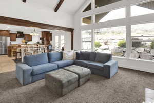Living room featuring plenty of natural light, light carpet, and beam ceiling