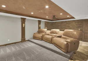 Cinema with crown molding, carpet flooring, a tray ceiling, and decorative columns