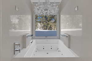 Bathroom featuring a bath and a chandelier