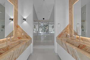 Bathroom featuring vaulted ceiling and walk in shower and separate sinks.