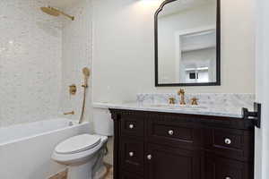 Full bathroom featuring tile patterned flooring, vanity, tiled shower / bath, and toilet