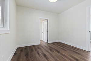 Unfurnished room featuring dark wood-type flooring