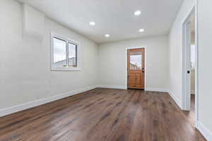 Empty room featuring dark wood-type flooring