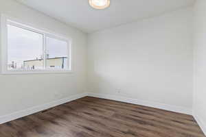 Unfurnished room featuring dark wood-type flooring