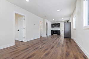 Unfurnished living room featuring dark wood-type flooring