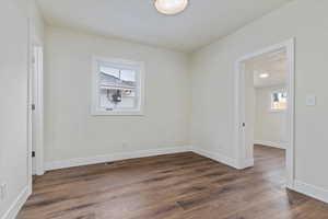 Empty room featuring dark hardwood / wood-style flooring