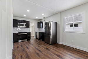 Kitchen featuring tasteful backsplash, stainless steel appliances, dark hardwood / wood-style floors, and sink