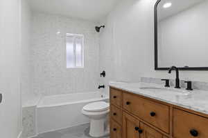 Full bathroom with tile patterned floors, vanity, toilet, and tiled shower / bath