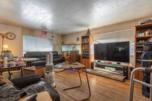 Living room with a textured ceiling and light wood-type flooring