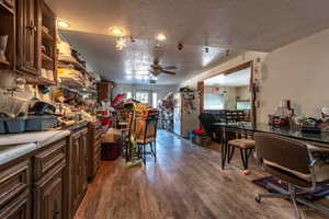 Kitchen with dark brown cabinetry, white fridge, dark hardwood / wood-style floors, and ceiling fan