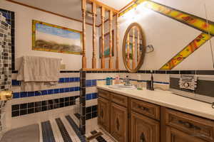 Bathroom featuring tile patterned flooring, a textured ceiling, vanity, and tile walls