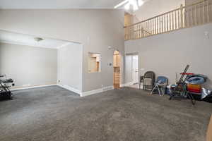 Interior space with high vaulted ceiling, ornamental molding, and ceiling fan