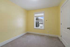 Unfurnished room featuring light carpet