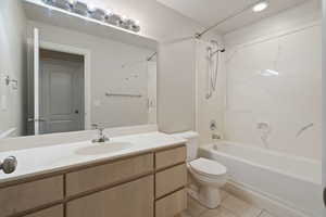 Full bathroom with shower / bathtub combination, vanity, toilet, and tile patterned flooring