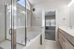 Bathroom with tile patterned floors, vanity, shower with separate bathtub, and a textured ceiling