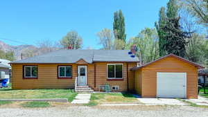 View of front of property featuring a chimney, roof with shingles, a mountain view, and entry steps