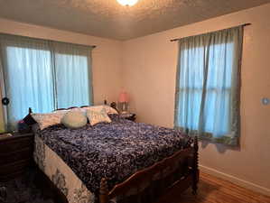 Bedroom #1 with hardwood / wood-style flooring and a textured ceiling