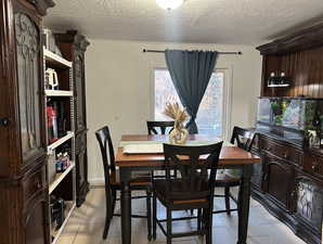 Tiled dining space with a textured ceiling