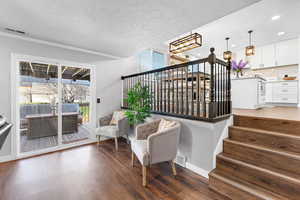 Living area with crown molding and wood-type flooring