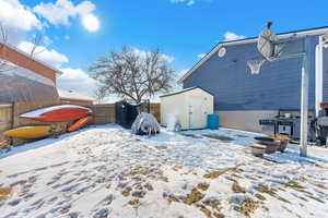 Yard layered in snow with a storage unit