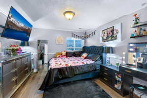 Bedroom with crown molding, dark wood-type flooring, and a textured ceiling