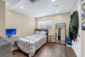 Bedroom with dark hardwood / wood-style floors and a textured ceiling