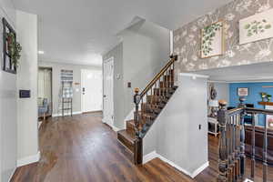 Entrance foyer featuring crown molding and dark hardwood / wood-style floors