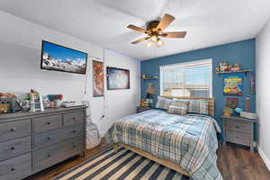 Bedroom featuring ceiling fan, dark hardwood / wood-style floors, and a textured ceiling