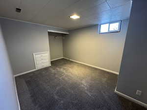 Unfurnished bedroom featuring dark colored carpet and a closet