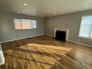 Unfurnished living room with hardwood / wood-style floors and a tile fireplace