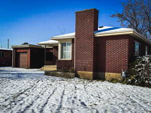 View of snowy exterior with a garage