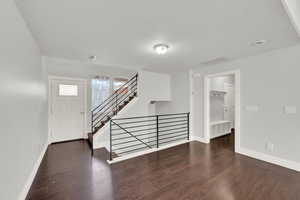 Foyer entrance with dark wood-type flooring and a textured ceiling