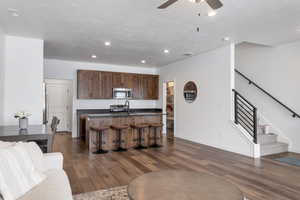 Living room featuring ceiling fan, dark hardwood / wood-style flooring, and sink