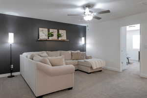 Living room featuring ceiling fan and light carpet