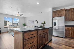 Kitchen featuring a center island with sink, light hardwood / wood-style flooring, sink, ceiling fan, and stainless steel appliances