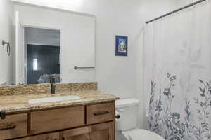 Bathroom with vanity, toilet, and a shower with shower curtain