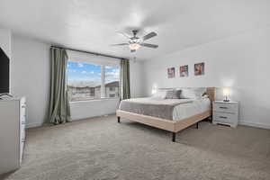 Carpeted bedroom featuring ceiling fan