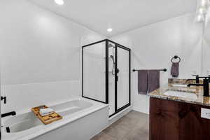 Bathroom featuring tile patterned floors, plus walk in shower, and vanity