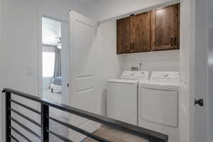 Clothes washing area with washer and clothes dryer, cabinets, and ceiling fan