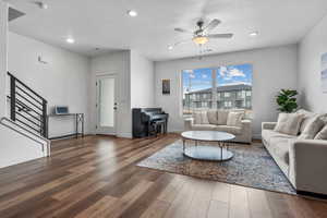 Living room with dark wood-type flooring and ceiling fan