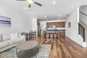 Living room with ceiling fan, sink, and dark hardwood / wood-style flooring